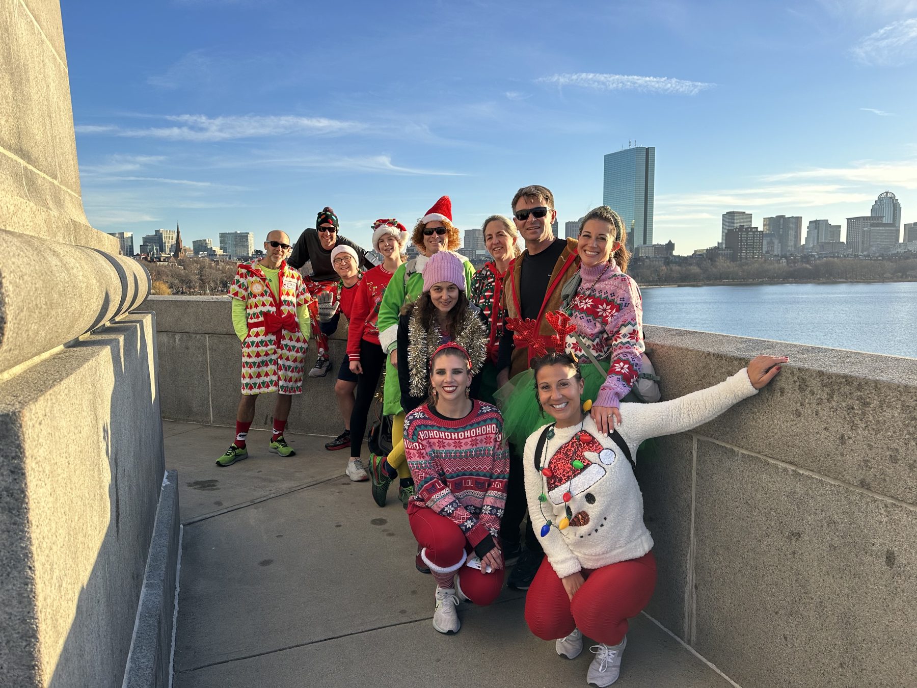 Gallopers in holiday outfits on the Longfellow Bridge with the Boston skyline and Charles River behind them